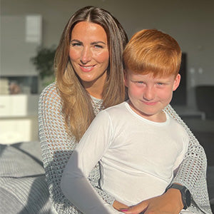 Mutter und Sohn mit empfindlicher Haut tragen TRUSTGARN Kleidung im Sonnenlicht