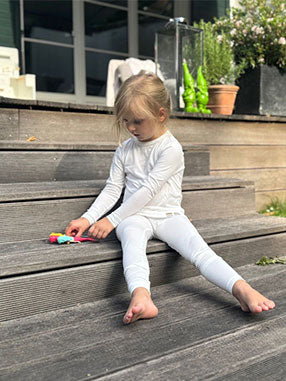 Kind läuft eine Treppe hinauf und trägt hautfreundliche TRUSTGARN Kleidung für empfindliche Haut